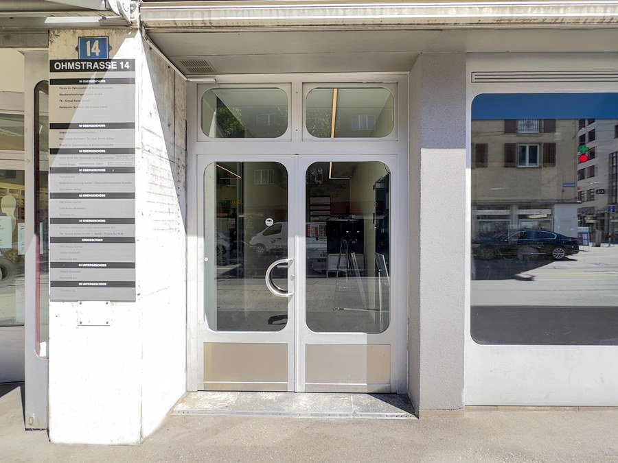 Hauseingang an der Ohmstrasse 14 in Zürich-Oerlikon, links die Firmentafel des Hauses
